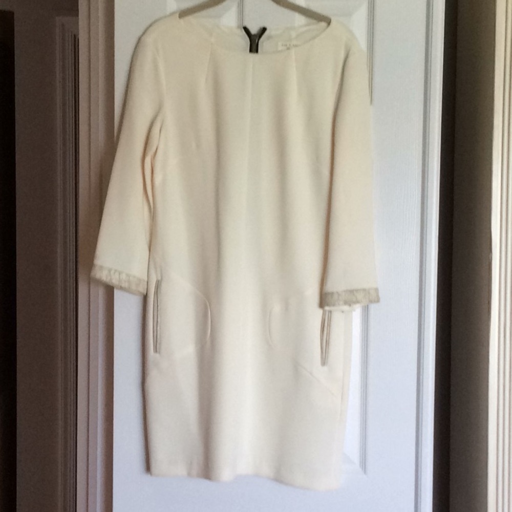 Off white dress with gold trim.